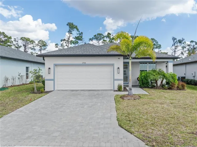 Single story home featuring a front lawn, stucco siding, a garage, and decorative driveway