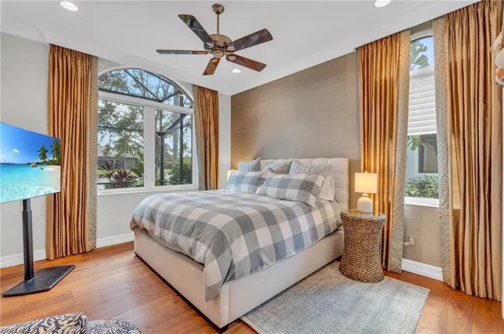 Bedroom featuring light hardwood / wood-style flooring, multiple windows, and ceiling fan