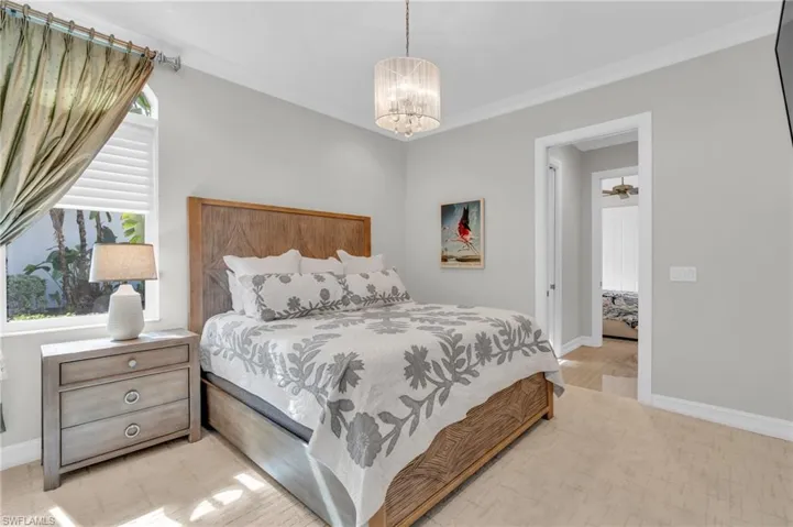 Bedroom featuring light hardwood / wood-style floors, crown molding, and a chandelier