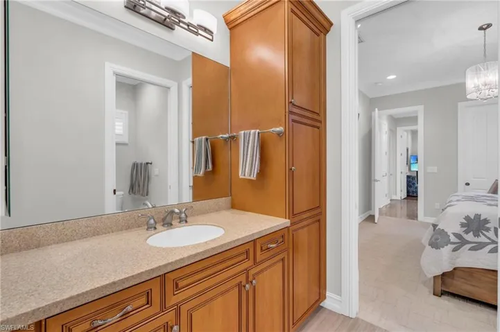 Bathroom with vanity, a chandelier, and crown molding