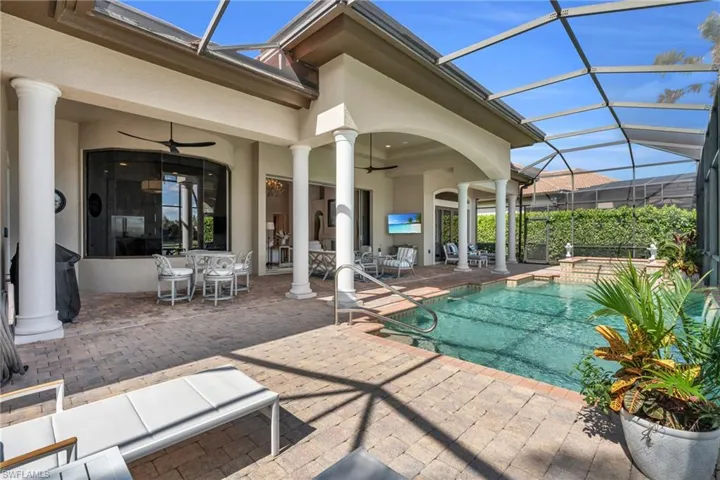 View of swimming pool featuring a hot tub, a lanai, a patio, and ceiling fan