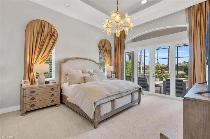 Bedroom featuring multiple windows, an inviting chandelier, and access to exterior