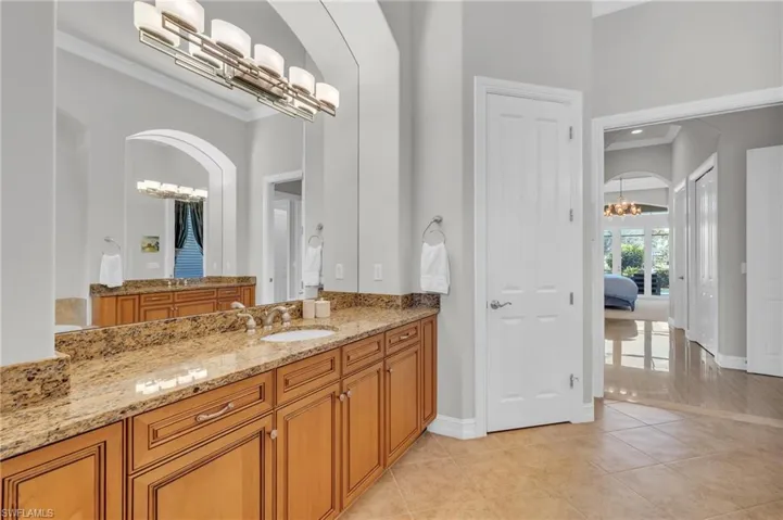 Bathroom featuring vanity, a notable chandelier, and tile patterned flooring