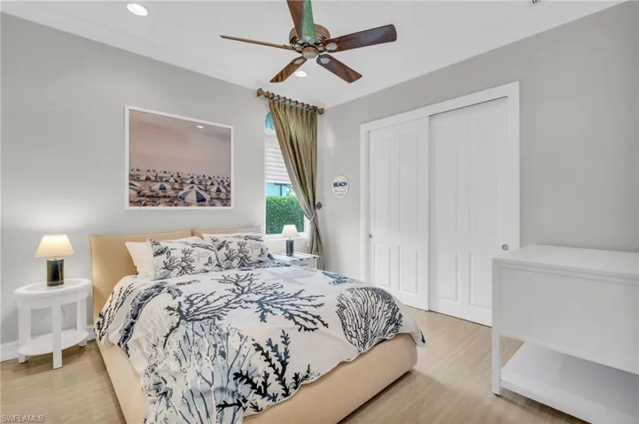 Bedroom with ornamental molding, hardwood / wood-style flooring, a closet, and ceiling fan