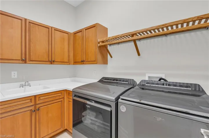 Clothes washing area with sink, washing machine and clothes dryer, and cabinets