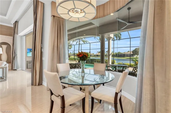 Dining area with light hardwood / wood-style flooring, an AC wall unit, a water view, and ceiling fan