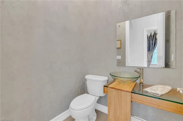 Bathroom with vanity, toilet, and wood-type flooring