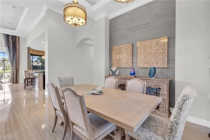 Dining area with ornamental molding and hardwood / wood-style flooring
