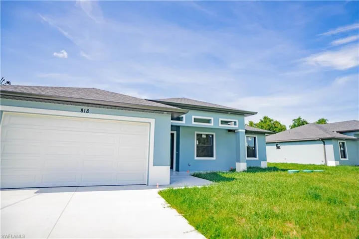 View of front of home with a garage and a front yard