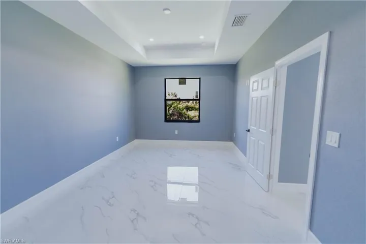Unfurnished room featuring tile patterned flooring and a tray ceiling