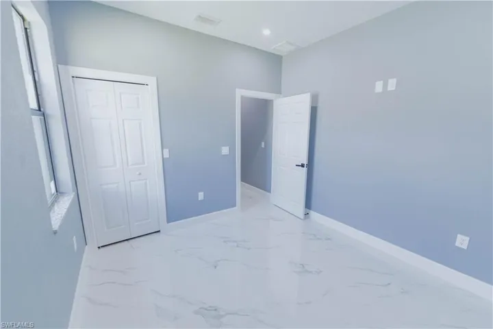 Unfurnished bedroom featuring a closet and light tile patterned floors