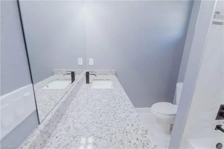 Full bathroom featuring vanity, shower / bath combination, toilet, and tile patterned floors