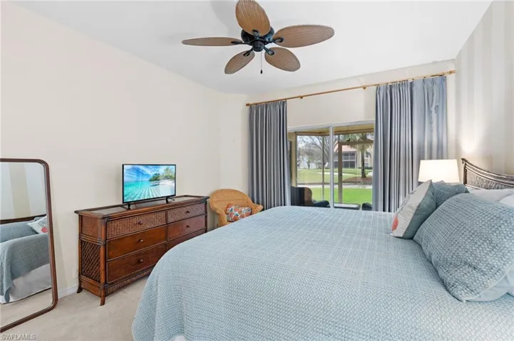 Carpeted bedroom featuring access to outside and ceiling fan