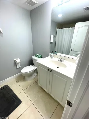 Full bathroom featuring vanity, a shower with curtain, and light tile patterned flooring