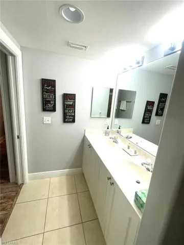 Full bathroom featuring double vanity and light tile patterned floors