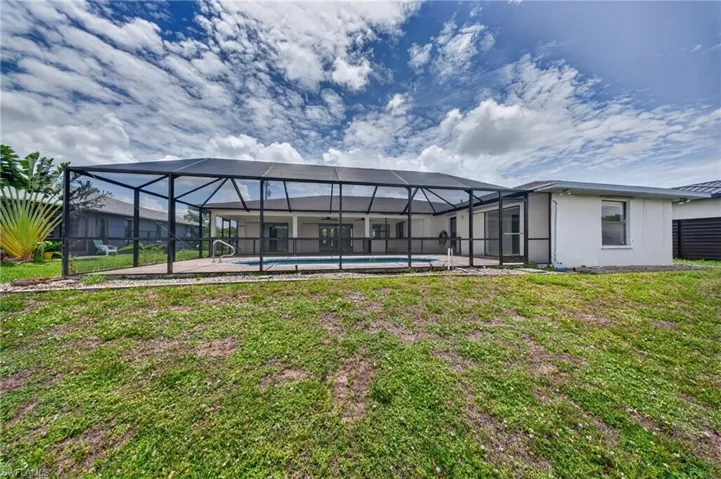 Expansive screened-in pool enclosure featuring a swimming pool and concrete patio