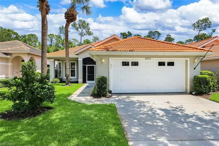 Front exterior featuring a terracotta tile roof, a two-car garage with transom windows, and a screened entry