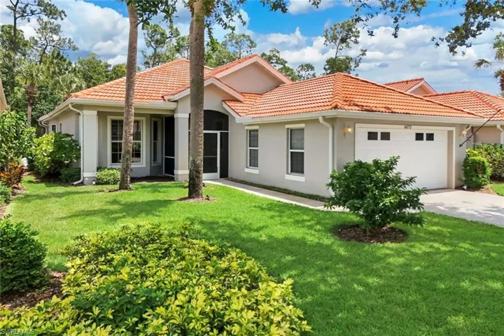 Exterior featuring a concrete tile roof, stucco finish, attached two-car garage, and a screened front entry