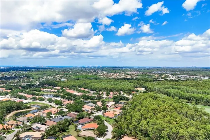 Expansive aerial perspective showcasing a residential community with mature trees and water features