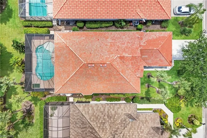 Aerial perspective showcasing the property's red tile roof and a screened-in swimming pool