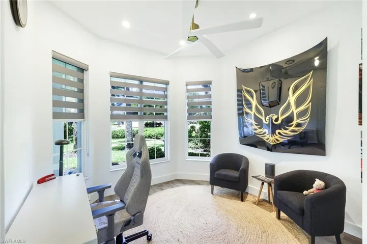 Room with multiple windows featuring blinds, a ceiling fan with integrated lighting, recessed lighting, and wood-finish flooring