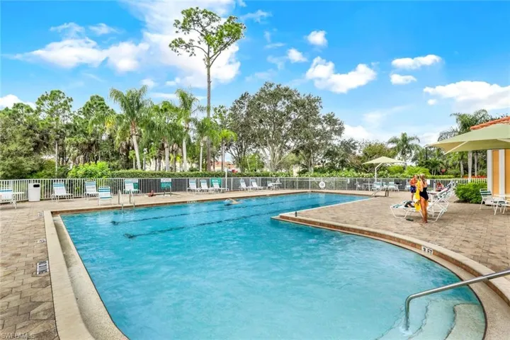 Expansive outdoor swimming pool with integrated swim lanes, surrounded by a paver deck and lounge seating