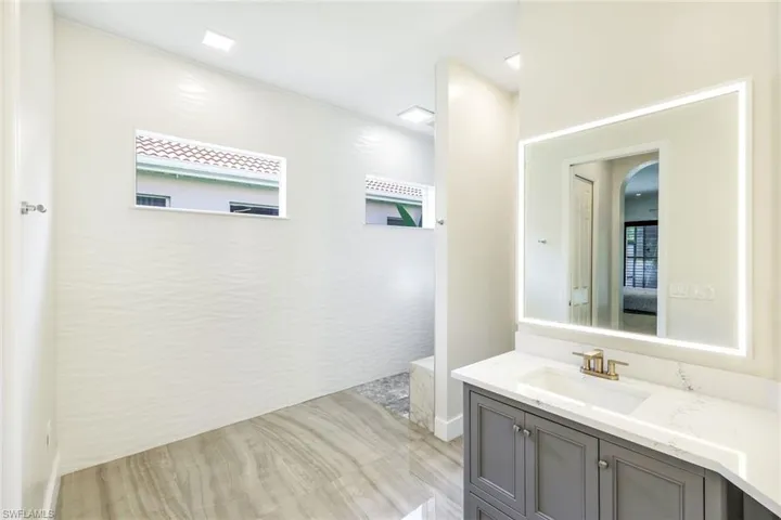 Bathroom featuring a single vanity with a white countertop and gold-toned faucet