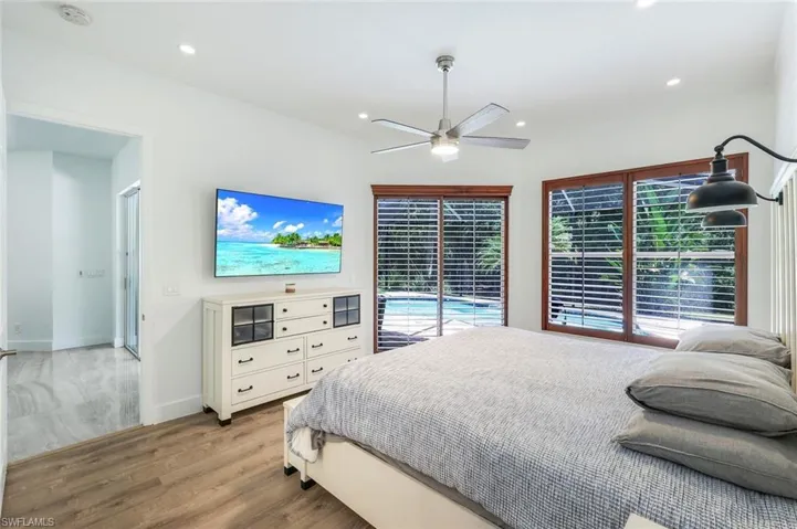 Spacious room featuring wood-finish flooring, recessed lighting, and a ceiling fan