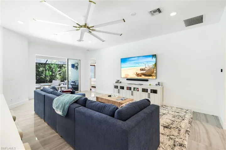 Living area featuring a multi-blade ceiling fan, recessed lighting, and large format tile flooring