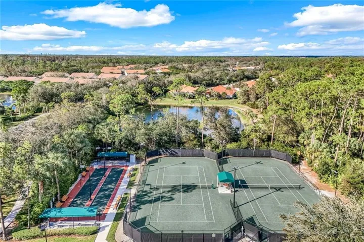 Community recreation area featuring two tennis courts, two bocce ball courts, and surrounding natural landscaping