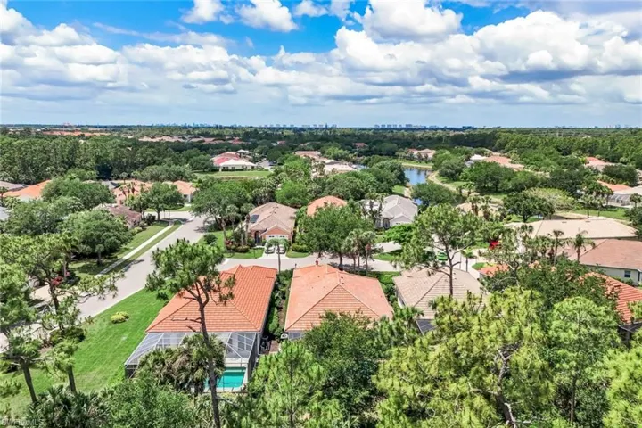 Aerial perspective showcasing a residential community with mature landscaping and a visible water feature
