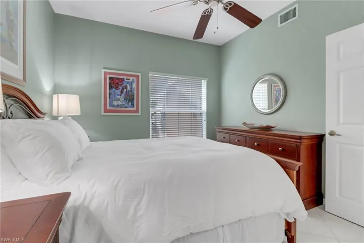 Bedroom with ceiling fan and light tile patterned flooring