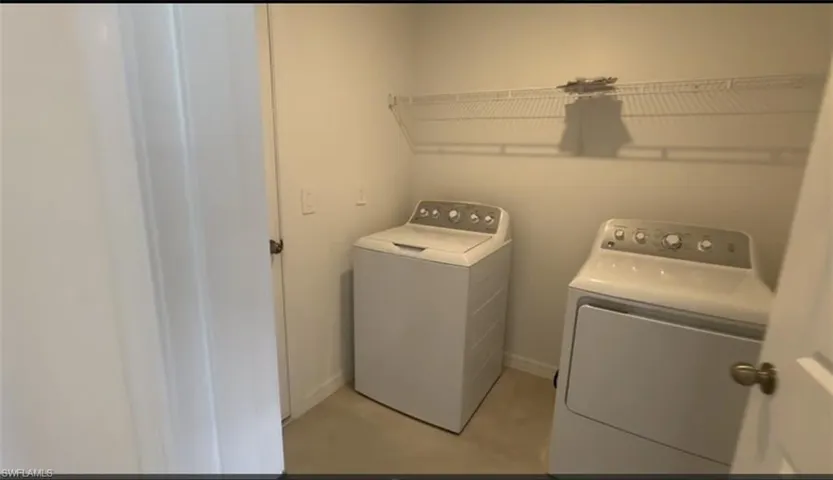 Laundry room with separate washer and dryer and baseboards