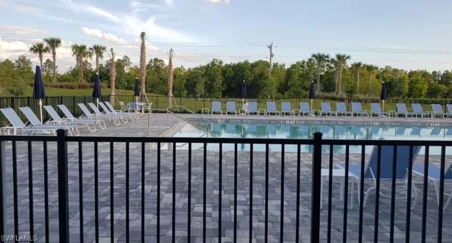 Community pool featuring a patio and view of scattered trees