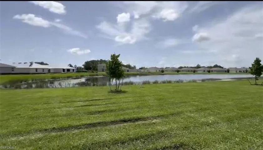 View of green lawn featuring a water view