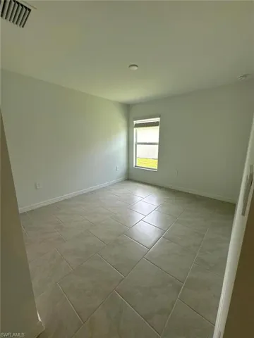 Unfurnished room with baseboards and light tile patterned flooring