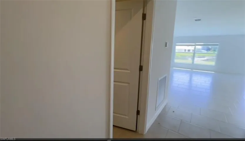 Hallway featuring light tile patterned flooring