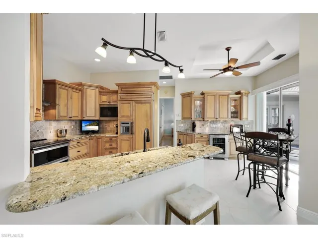 Kitchen featuring appliances with stainless steel finishes, a tasteful backsplash, granite countertops