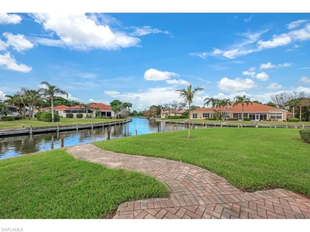 View of dock featuring a large yard and a water view and outside patio to enjoy evening sunsets