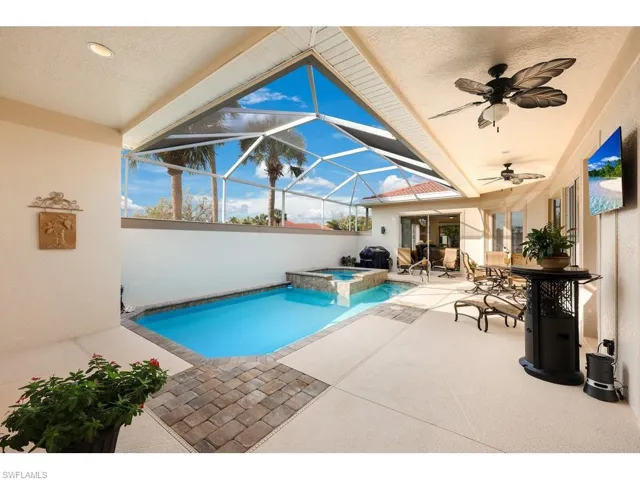 View of swimming pool with an in ground hot tub with individual heat control and overspill