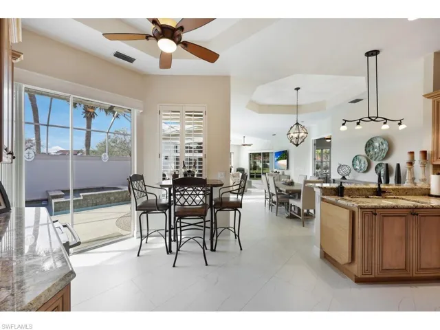 Breakfast dining area with a tray ceiling, sliders to pool, the home is built around the pool