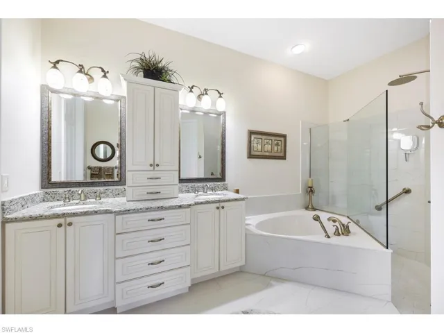 Bathroom with vanity, two sinks, and separate shower and tub, newer recently updated. Large walk in closet off Primary Bath