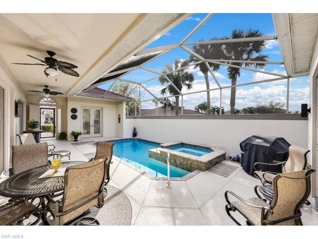 View of pool with grilling area, ceiling fan, plenty of seating.