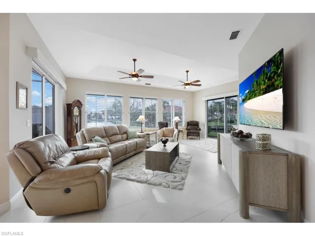 Living room with newer tiled floors, a raised ceiling, and water views