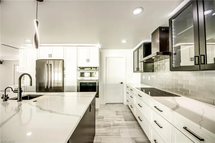 Bathroom with vanity, a stall shower, tile patterned floors, and recessed lighting