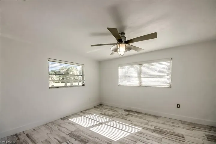 Empty room featuring baseboards and light wood-type flooring