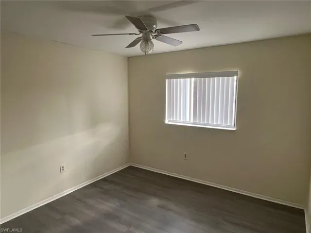 Spare room featuring dark wood finished floors and ceiling fan