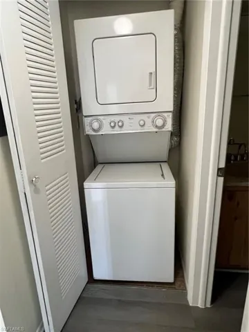 Laundry area featuring estacked washer and dryer and wood finished floors