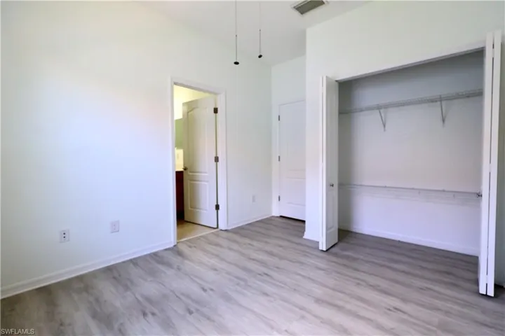 Unfurnished bedroom with light wood-type flooring and a closet