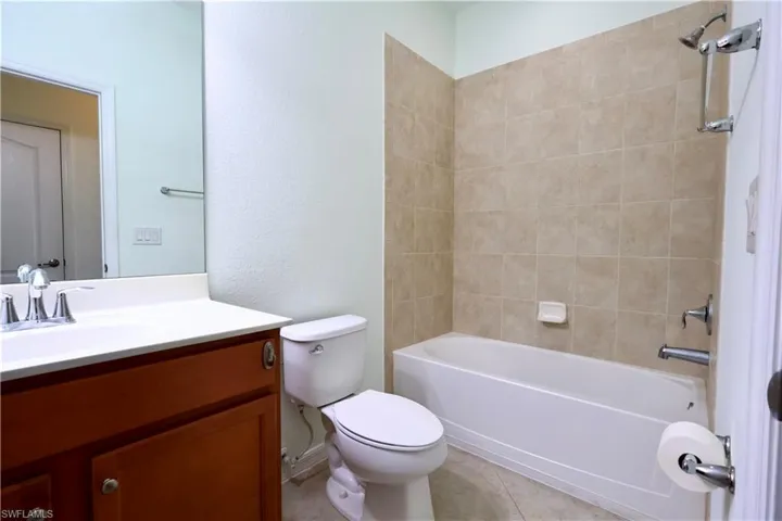 Full bathroom with vanity, bathing tub / shower combination, and tile patterned flooring